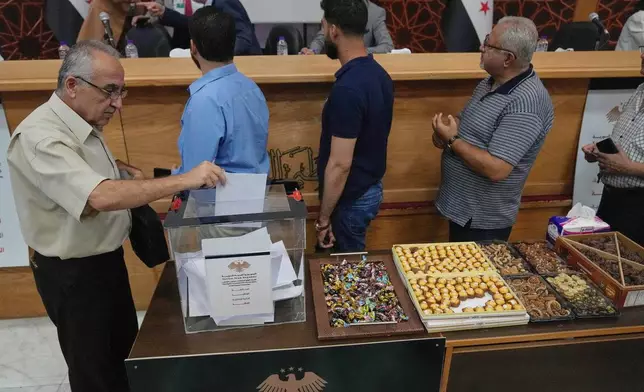 A Syrian electoral college member casts his vote during the parliamentary elections at Latakia's Governor ballot station, in the coastal city of Latakia, Syria, Sunday, Oct. 5, 2025. (AP Photo/Hussein Malla)