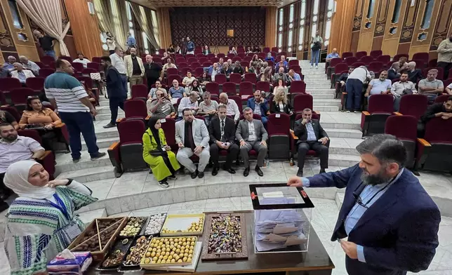A Syrian electoral college member, right, casts his vote during the parliamentary elections at Latakia's Governor ballot station, in the coastal city of Latakia, Syria, Sunday, Oct. 5, 2025. (AP Photo/Hussein Malla)