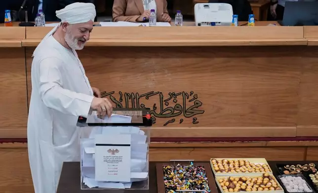 A Syrian cleric man from the electoral college member casts his vote during the parliamentary elections at Latakia's Governor ballot station, in the costal city of Latakia, Syria, Sunday, Oct. 5, 2025. (AP Photo/Hussein Malla)