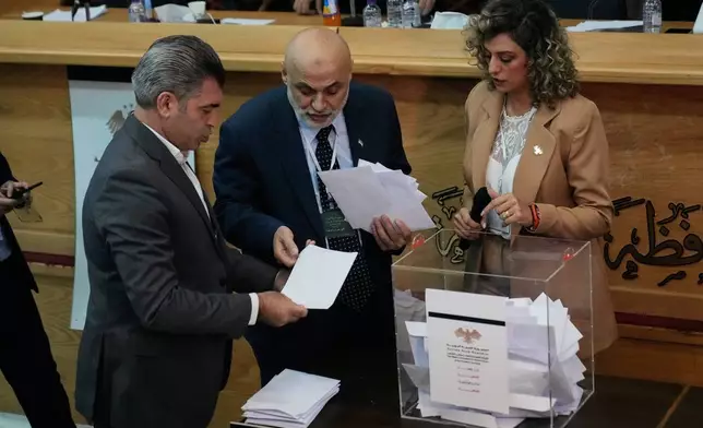 Syrian election officials count ballots shortly after polling stations closed at Latakia's Governor building, in the coastal city of Latakia, Syria, Sunday, Oct. 5, 2025. (AP Photo/Hussein Malla)