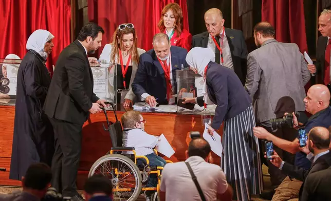 Syrian electoral college members line up to cast their ballots in a parliamentary election at a polling station in Damascus, Syria, Sunday, Oct. 5, 2025. (AP Photo/Omar Sanadiki)