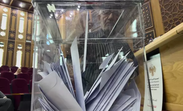 A Syrian electoral college member casts his vote during a parliamentary election at Latakia's Governor ballot station in Latakia, Syria, Sunday, Oct. 5, 2025. (AP Photo/Hussein Malla)