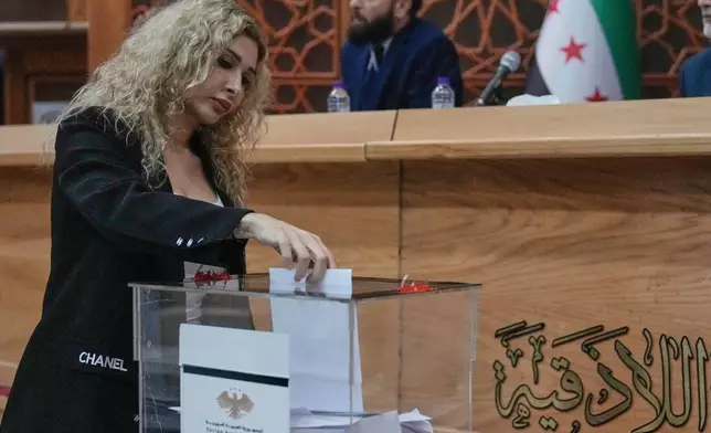 Syrian Alawite candidate Reem Kahila casts her vote during the parliamentary elections at Latakia's Governor ballot station, in the coastal city of Latakia, Syria, Sunday, Oct. 5, 2025. (AP Photo/Hussein Malla)