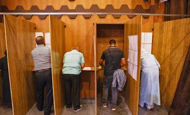 Electoral college members collect their ballots for a parliamentary election at a polling station in Aleppo, Syria, Sunday, Oct. 5, 2025. (AP Photo/Omar Albam)