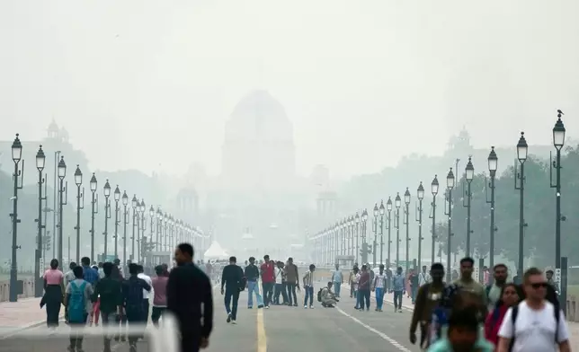 People walk on a street enveloped in smog, in New Delhi, India, Tuesday, Oct. 28, 2025. (AP Photo/Manish Swarup)