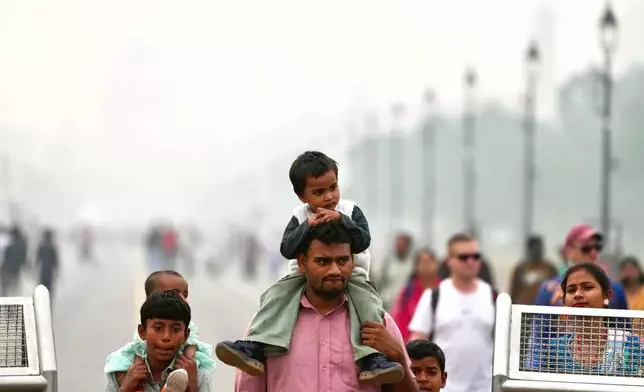 People walk on a street enveloped in smog, in New Delhi, India, Tuesday, Oct. 28, 2025. (AP Photo/Manish Swarup)