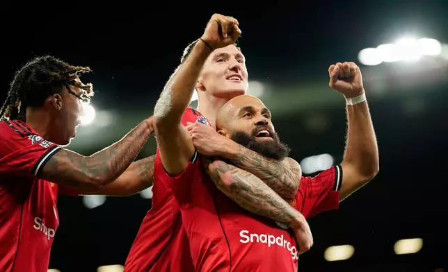 Manchester United's Bryan Mbeumo, front, celebrates with Benjamin Sesko after scoring his side's third goal during the English Premier League soccer match between Manchester United and Brighton &amp; Hove Albion in Manchester, England, Saturday, Oct. 25, 2025. (AP Photo/Dave Thompson)