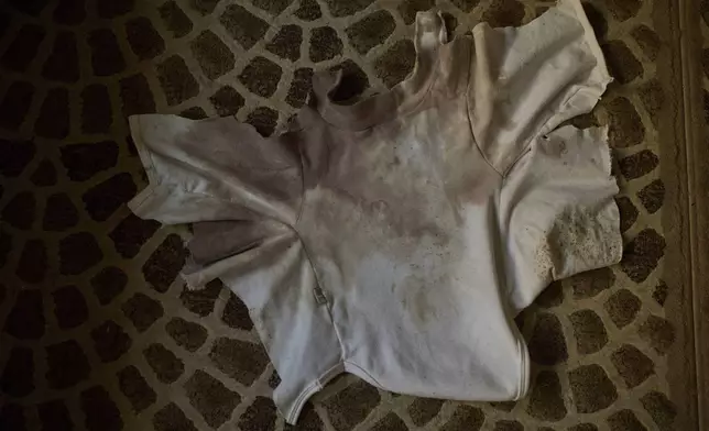 A blood-stained shirt that Tayma Asous says was worn by her 2-year-old daughter, Layla Al-Khatib, when she was shot in the head by Israeli gunfire, is laid out at their home in the village of Muthallath ash-Shuhada, near the West Bank city of Jenin, March 11, 2025. (AP Photo/Leo Correa)