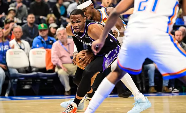Sacramento Kings guard Russell Westbrook (18) drives against Oklahoma City Thunder guard Shai Gilgeous-Alexander (2) during the first half of an NBA basketball game between Sacramento Kings and Oklahoma City Thunder, Tuesday, Oct. 28, 2025, in Oklahoma City. (AP Photo/Gerald Leong)