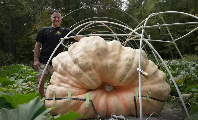 Tony Scott stands with the pumpkin he grew in his Wappingers Falls, N.Y., backyard on Sept. 17, 2025. (AP Photo/Shelby Lum)