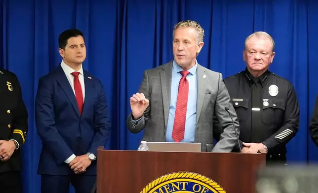 Special Agent in Charge Kenny Cooper, of the Bureau of Alcohol, Tobacco, Firearms and Explosives, Los Angeles Field Division, middle, speaks between Acting U.S. Attorney Bill Essayli, left, and Los Angeles Police Chief Jim McDonnell, right, during a news conference announcing an arrest made in the Palisades Fire, Wednesday, Oct. 8, 2025, in Los Angeles. (AP Photo/Damian Dovarganes)