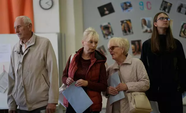 CAPTION CORRECTS LOCATION - People wait in line at a polling station for a general election at a poling station in Brno, Czech Republic, Friday, Oct. 3, 2025. (AP Photo/Darko Bandic)