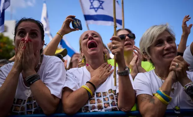 People react as they watch a live broadcast of Israeli hostages released from Hamas captivity in the Gaza Strip, at a plaza known as hostages square in Tel Aviv, Israel, Monday, Oct. 13, 2025. (AP Photo/Oded Balilty)