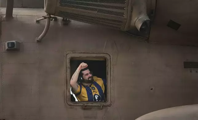 Ziv Berman, an Israeli hostage released from the Gaza Strip gestures from the window of a helicopter landing at the Sheba Medical Center in Ramat Gan, Israel, Monday, Oct. 13, 2025. (AP Photo/Leo Correa)