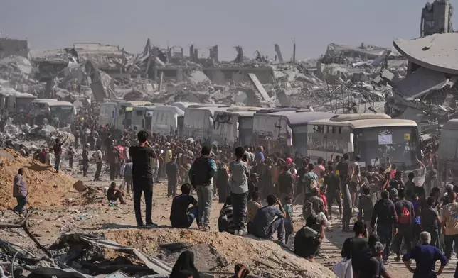 Buses carrying freed Palestinian prisoners drive past destroyed buildings in the Gaza Strip after their release from Israeli jails under a ceasefire agreement between Hamas and Israel, in Khan Younis, southern Gaza Strip, Monday, Oct. 13, 2025. (AP Photo/Jehad Alshrafi)