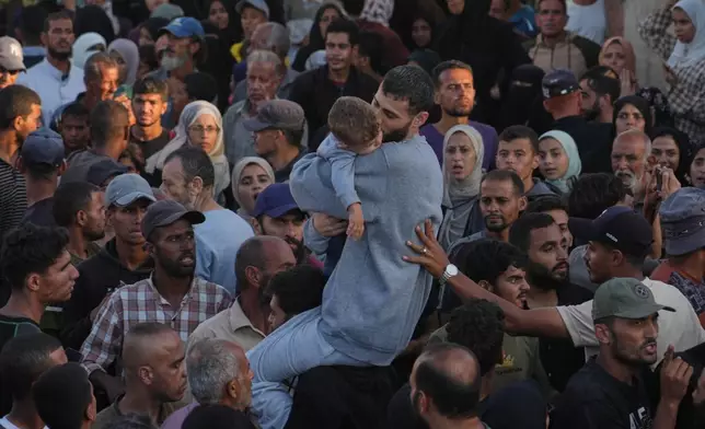A freed Palestinian prisoner, center, hugs a child as he is greeted upon arriving in the Gaza Strip after being released from Israeli jails under a ceasefire agreement between Hamas and Israel, in Khan Younis, southern Gaza Strip, Monday, Oct. 13, 2025. (AP Photo/Jehad Alshrafi)