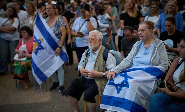 Attendees listen to a concert at a plaza known as hostages square, in Tel Aviv, Israel, Sunday, Oct. 12, 2025. (AP Photo/Emilio Morenatti)