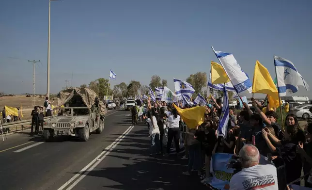 People react as a convoy carrying the hostages released from the Gaza Strip arrives at a military base near Reim, southern Israel, on Monday, Oct. 13, 2025. (AP Photo/Leo Correa)