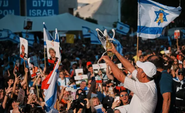 People react as they gather to watch a live broadcast of Israeli hostages released from Gaza at a plaza known as hostages square in Tel Aviv, Israel, Monday, Oct. 13, 2025. (AP Photo/Emilio Morenatti)