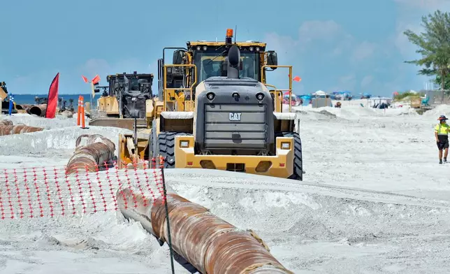 Workers replace the sand washed away by recent hurricanes along the gulf Thursday, Sept. 25, 2025, in Indian Rocks Beach, Fla. (AP Photo/Chris O'Meara)