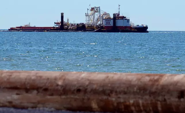 A dredge boat pumps sand back onto the beach along the gulf Thursday, Sept. 25, 2025, in Indian Rocks Beach, Fla. (AP Photo/Chris O'Meara)