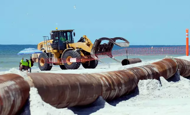 Workers replace the sand washed away by recent hurricanes along the gulf Thursday, Sept. 25, 2025, in Indian Rocks Beach, Fla. (AP Photo/Chris O'Meara)