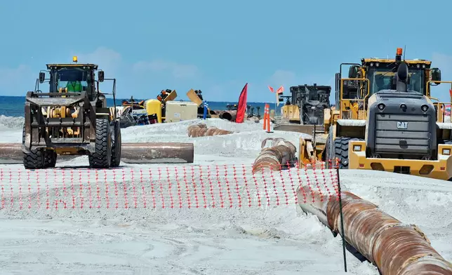 Workers replace the sand washed away by recent hurricanes along the gulf Thursday, Sept. 25, 2025, in Indian Rocks Beach, Fla. (AP Photo/Chris O'Meara)