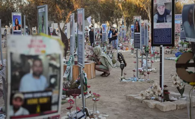 People visit the site of the Nova music festival, where hundreds of revelers were killed and abducted by Hamas and taken into Gaza, as Israel marks the second year anniversary of the attack, near Kibbutz Reim, southern Israel, Tuesday, Oct. 7, 2025. (AP Photo/Ariel Schalit)