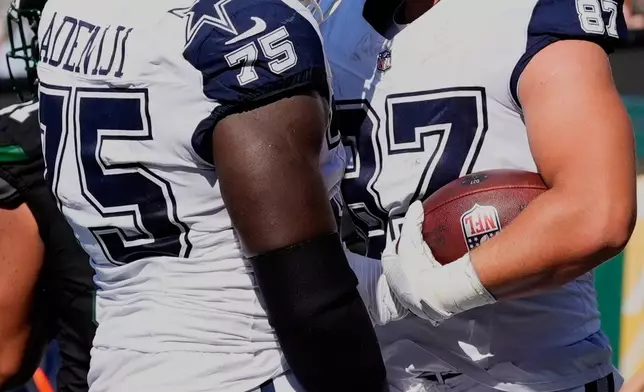 Dallas Cowboys' Jake Ferguson celebrates his touchdown catch with Hakeem Adeniji during the first half of an NFL football game against the New York Jets Sunday, Oct. 5, 2025, in East Rutherford, N.J. (AP Photo/Yuki Iwamura)