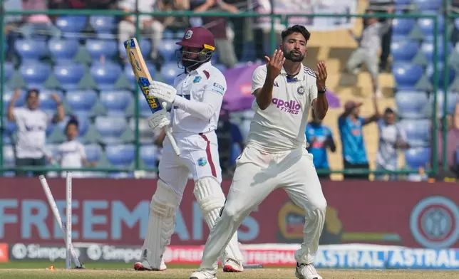 India's Mohammed Siraj celebrates the dismissal of West Indies' Jomel Warrican, left, on the third day of the second cricket test match between India and West Indies at the Arun Jaitley Stadium in New Delhi, India, Sunday, Oct.12, 2025. (AP Photo/Manish Swarup)