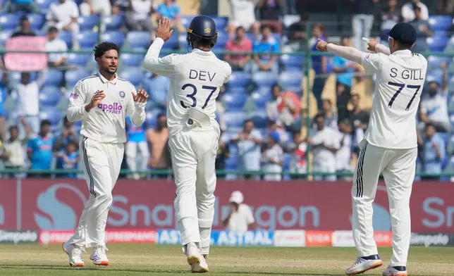 India's Kuldeep Yadav, left, celebrates the dismissal of West Indies' Justin Greaves with teammates on the third day of the second cricket test match between India and West Indies at the Arun Jaitley Stadium in New Delhi, India, Sunday, Oct.12, 2025. (AP Photo/Manish Swarup)