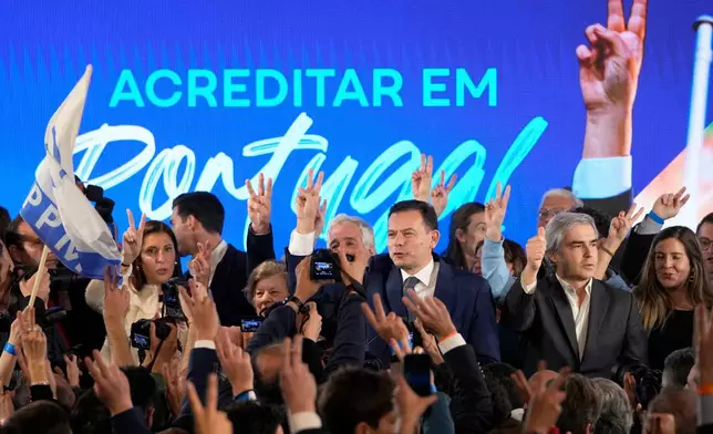 FILE - Luis Montenegro, leader of the center-right Democratic Alliance, center, and his wife Carla, at left, gesture to supporters after claiming victory in Portugal's election, in Lisbon, on March 11, 2024. AP Photo/Armando Franca, File)