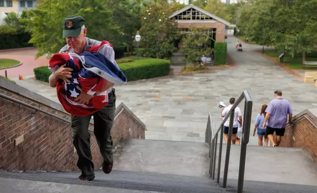 Park rangers spend the first morning of the government shutdown closing down the Fort Sumter National Monument center including taking down the American flag Wednesday, Oct. 1, 2025, in Charleston, S.C. (Grace Beahm Alford/The Post And Courier via AP)