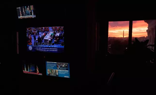 The sun sets behind the Capitol and Washington Monument, as a vote fails in the Senate which is expected to lead to a government shutdown, Tuesday, Sept. 30, 2025, as seen from inside the Capitol, in Washington. (AP Photo/Jacquelyn Martin)