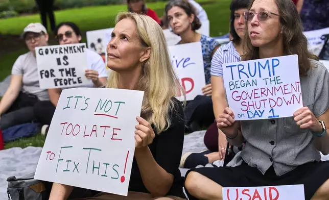 Layne Morrison, left, of Washington, and Courtney Creek, of Silver Spring, Md., who were let go from their jobs with the Education Department and a USAID funded grant respectively, hold signs about the looming government shutdown, Tuesday, Sept. 30, 2025, on Capitol Hill in Washington, during a rally with former federal employees. (AP Photo/Jacquelyn Martin)