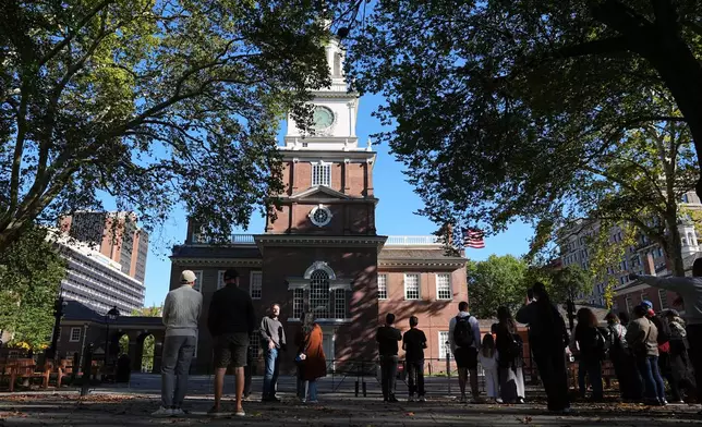 Tourist view Independence Hall from outside a barricade in Philadelphia, Wednesday, Oct. 1, 2025. (AP Photo/Matt Rourke)