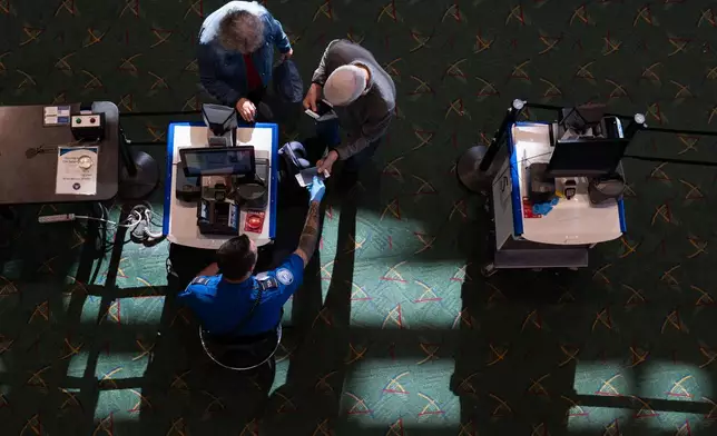 A Transportation Security Administration worker screens travelers at a security checkpoint at Portland International Airport on Wednesday, Oct. 1, 2025, in Portland, Ore. (AP Photo/Jenny Kane)