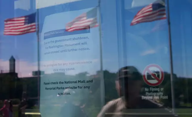 A tourist stops to read the sign announcing that the Washington Monument is closed on the first day of a partial government shutdown, Wednesday, Oct. 1, 2025, inWashington.(AP Photo/Pablo Martinez Monsivais)