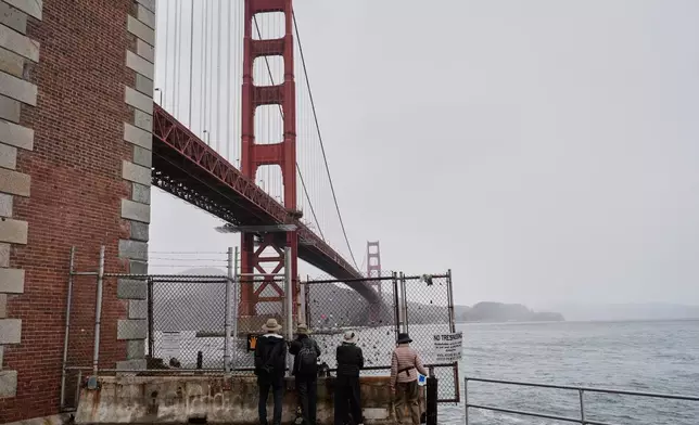 People look at the Golden Gate Bridge outside the Fort Point National Historic Site, which is closed due to a government shutdown, Wednesday, Oct. 1, 2025, in San Francisco. (AP Photo/Godofredo A. Vásquez)