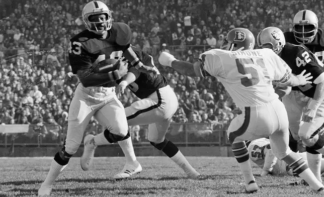 FILE - George Atkinson (43), of the Oakland Raiders, breaks inside Mike Simone (51) of the Denver Broncos as he returned a Broncos punt 32 yards, in Oakland, Calif., Dec. 16, 1973. (AP Photo, file)