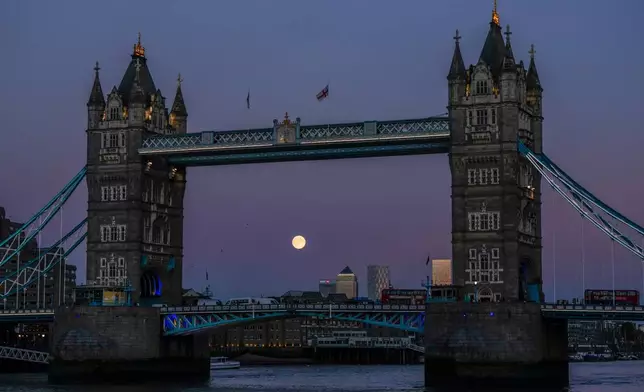 The Harvest Supermoon rises behind Tower Bridge, Monday, Oct. 6, 2025, in London. (AP Photo/Julia Demaree Nikhinson)