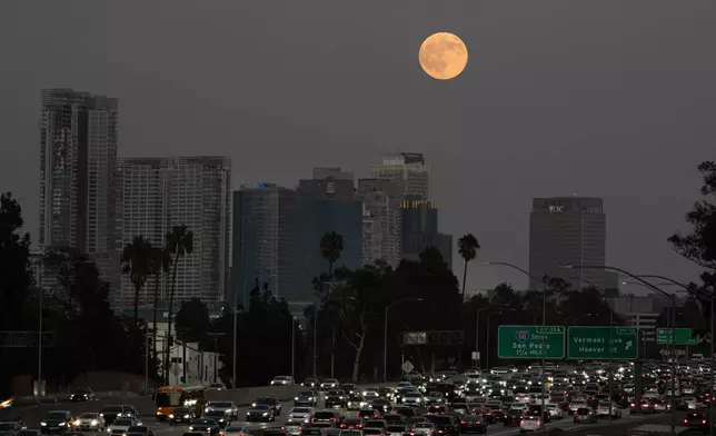 The Harvest Moon rises over Los Angeles, Monday, Oct. 6, 2025. (AP Photo/Jae C. Hong)