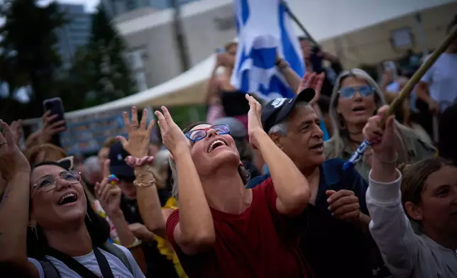 People react as they celebrate following the announcement that Israel and Hamas have agreed to the first phase of a peace plan to pause the fighting, at a plaza known as hostages square in Tel Aviv, Israel, Thursday, Oct. 9, 2025. (AP Photo/Emilio Morenatti)