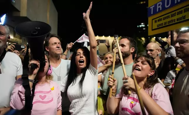 Einav Zangauker, center, mother of Matan Zangauker, who is being held hostage by Hamas, reacts as she and others celebrate following the announcement that Israel and Hamas have agreed to the first phase of a peace plan to pause the fighting, at a plaza known as Hostages Square in Tel Aviv, Israel, Thursday, Oct. 9, 2025. (AP Photo/Ohad Zwigenberg)