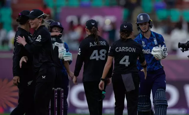 England's Amy Jones, extreme right, shake hands with New Zealand's players after winning the ICC Women's Cricket World Cup match against New Zealand at ACA–VDCA Cricket Stadium in Visakhapatnam, India, Sunday, Oct. 26, 2025. (AP Photo/Mahesh Kumar A.)