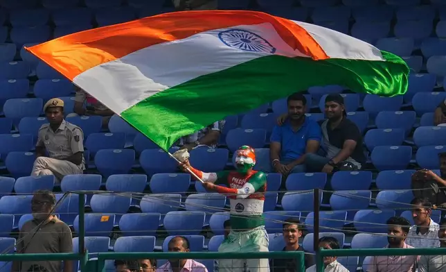 An cricket fan painted in colors of Indian flag waves national flag on the fifth day of the second cricket test match between India and West Indies at the Arun Jaitley Stadium in New Delhi, India, Tuesday, Oct.14, 2025. (AP Photo/Manish Swarup)