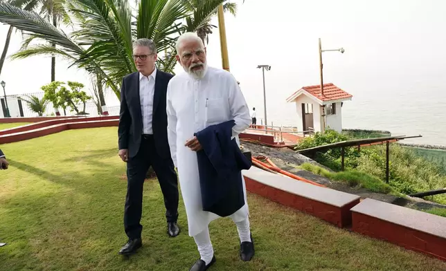 Britain's Prime Minister Keir Starmer, left, and Indian Prime Minister Narendra Modi walk through the gardens at Raj Bhavan in Mumbai, India, ahead of a bilateral meeting Thursday, Oct. 9, 2025. (Stefan Rousseau/Pool Photo via AP)