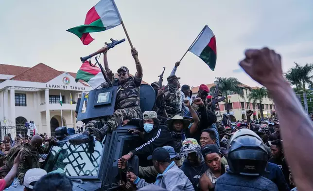 Soldiers are greeted by people gathering for a ceremony in tribute to demonstrators killed during recent anti-government protest in Antananarivo, Madagascar, Sunday, Oct. 12, 2025. (AP Photo/Mamyrael)
