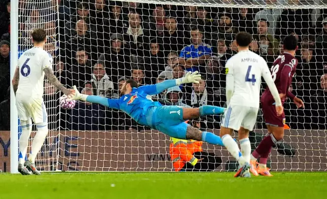 Leeds United's goalkeeper Lucas Perri dives in vain as West Ham United's Mateus Fernandes, right, scores their side's first goal during the English Premier League soccer match between Leeds United and West Ham United at Elland Road, Leeds, England, Friday Oct. 24, 2025. (Danny Lawson/PA via AP)