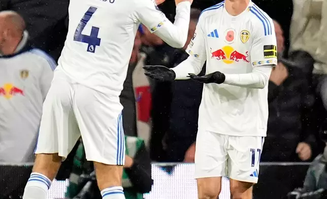 Leeds United's Brenden Aaronson, right, celebrates with Ethan Ampadu after scoring their side's first goal of the game during the English Premier League soccer match between Leeds United and West Ham United in Leeds, England, Friday Oct. 24, 2025. (Danny Lawson/PA via AP)